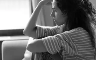 a woman with her hand to her forehead in distress